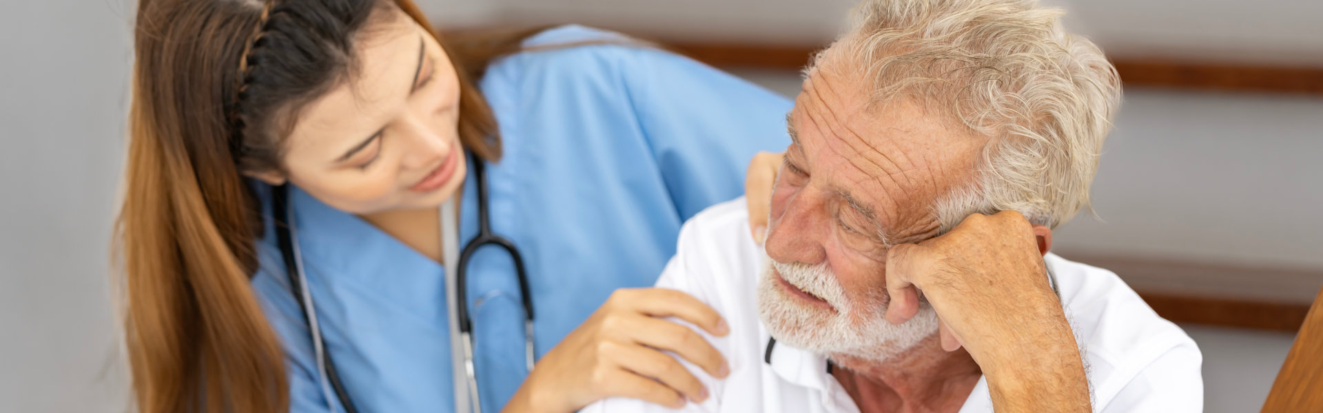 emotional elderly comforted by his caregiver